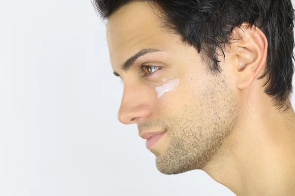 Retrato cercano de un hombre con crema hidratante en la cara — Foto de Stock