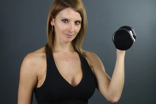 Güzel kadın bir dumbbell tutarak — Stok fotoğraf