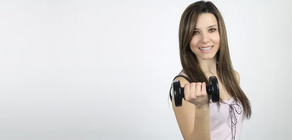 Beautiful woman holding a dumbbell — Stock Photo, Image