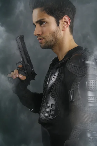 Super poldové - krásný opálený muž drží zbraň — Stock fotografie