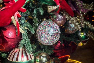 A sequin Christmas ball against the backdrop of a New Year tree