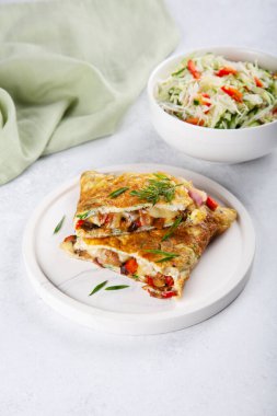 Biber, mantar, jambon ve peynirli omlet ve yeşil peçete..