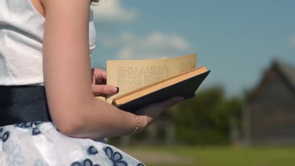 Meisje het lezen van een boek in park — Stockvideo