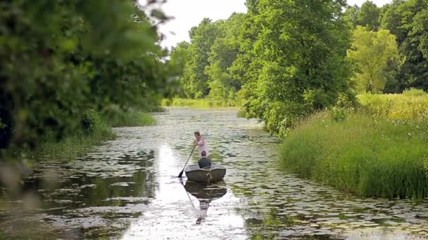 La chica flotando en el río en el bote y remando remos — Vídeos de Stock