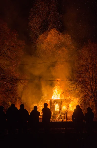 People in the background of a burning house — Stock Photo, Image