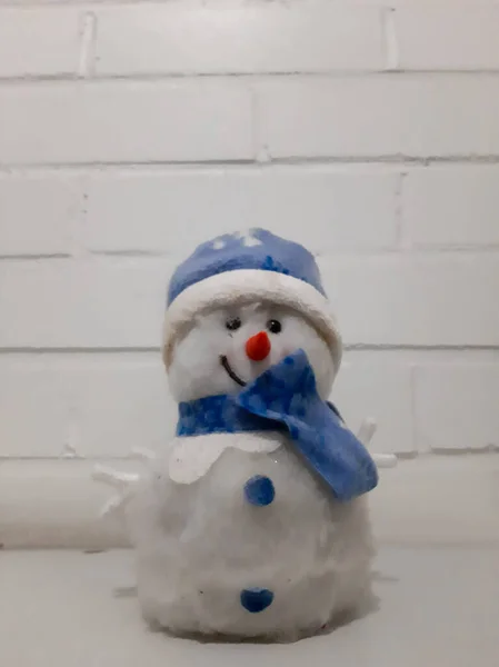    Oyuncak kardan adam beyaz bir duvarın arkasında