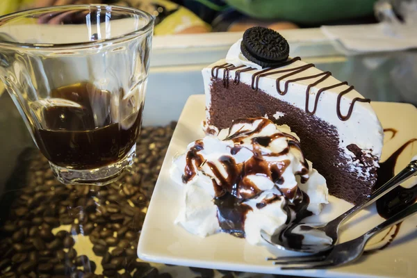 Tranche de gâteau au chocolat avec café noir — Photo