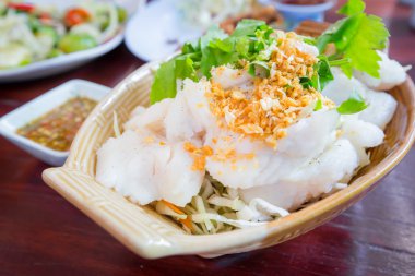 Dilim kızarmış sarımsak ile balık buğulama Tepesi ve baharatlı sos.