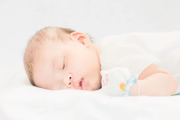 Fredelig baby ligger på en seng mens hun sover . – stockfoto