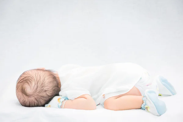 Bambino tranquillo sdraiato su un letto mentre dorme . — Foto Stock