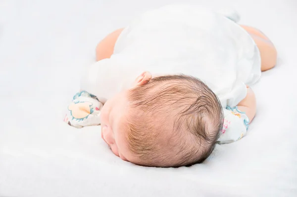 Fredelig baby ligger på en seng mens hun sover . – stockfoto