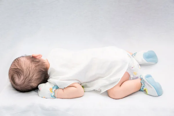 Bambino tranquillo sdraiato su un letto mentre dorme . — Foto Stock