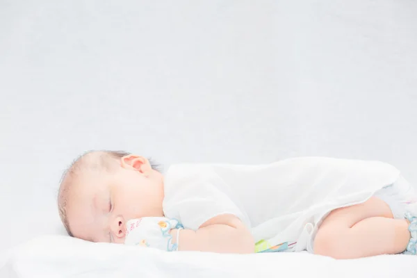 Bambino tranquillo sdraiato su un letto mentre dorme . — Foto Stock