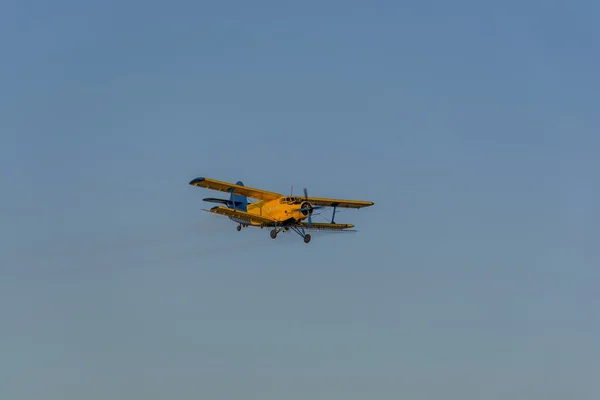 Crop duster spraying crops from the air in the morning light — Stock Photo, Image