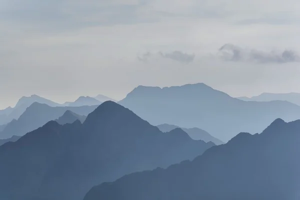 SiluetaSilueta de montañas azules en la niebla. Fondo sin costuras . Imagen de stock
