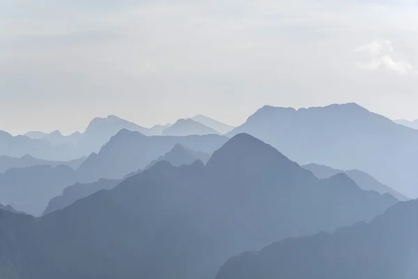SiluetaSilueta de montañas azules en la niebla. Fondo sin costuras . Fotos de stock