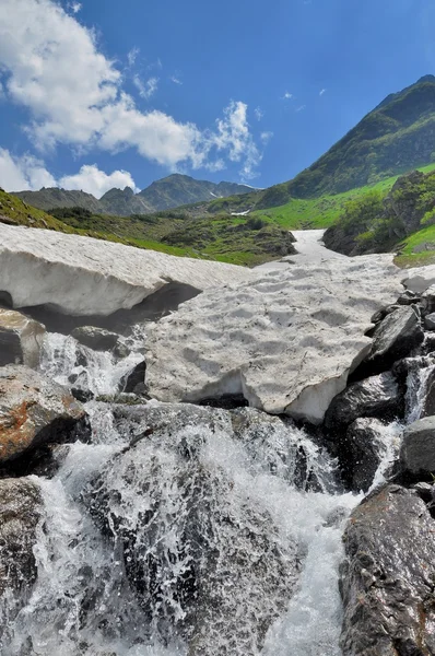 Grotte de neige sur la rivière de montagne en été — Photo