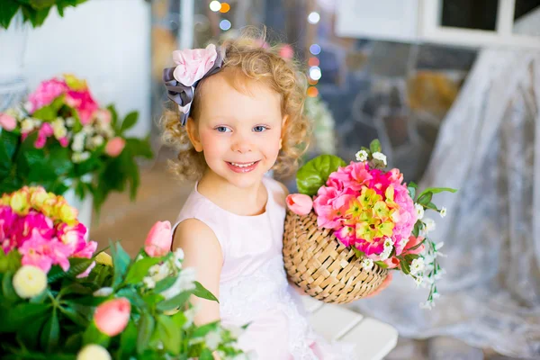 Little girl in a pink dress near pink flowers — Stock Photo, Image