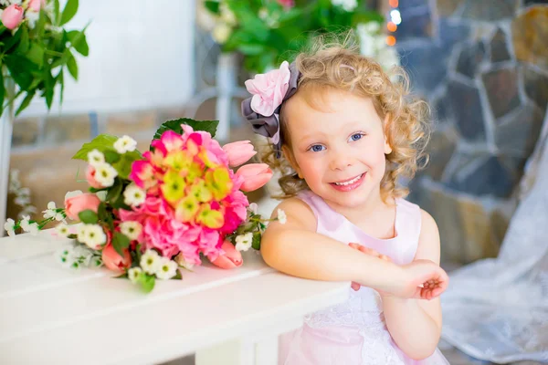 Menina em um vestido rosa perto de flores rosa — Fotografia de Stock