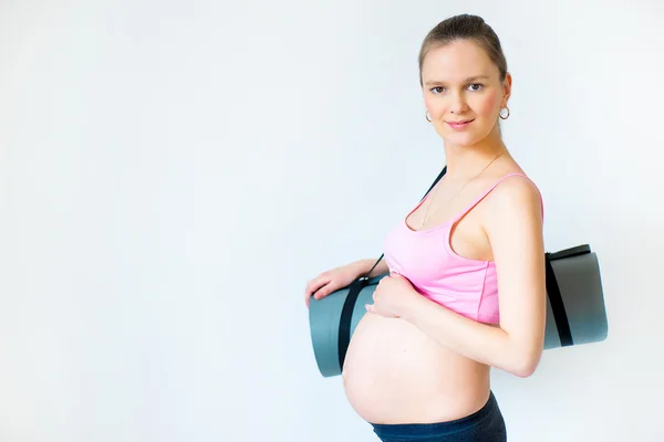 Dziewczyny w ciąży z Mata fitness w rękach — Zdjęcie stockowe