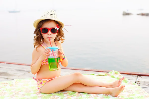 Niña bebiendo agua con gas en el muelle — Foto de Stock