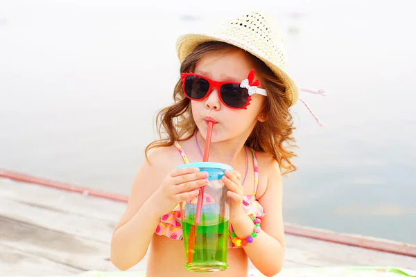 Niña bebiendo agua con gas en el muelle — Foto de Stock