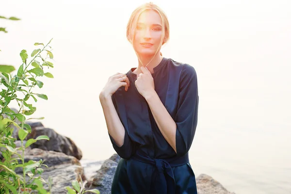 Chica posando cerca de la roca con hierba — Foto de Stock