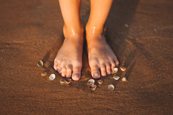 Füße am Strand mit Muscheln — Stockfoto