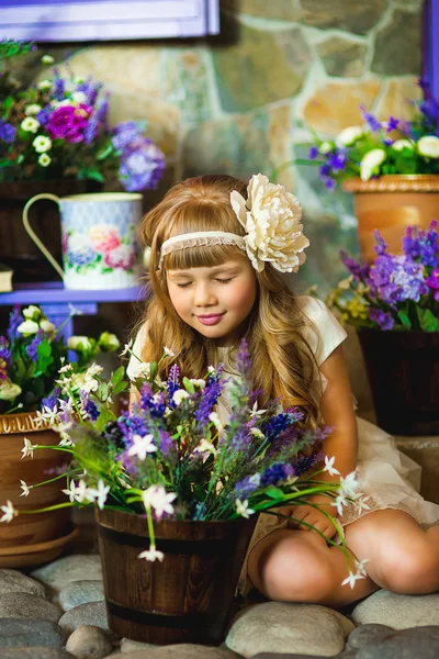 Das Mädchen in einem cremefarbenen Kleid mit lila Blüten — Stockfoto
