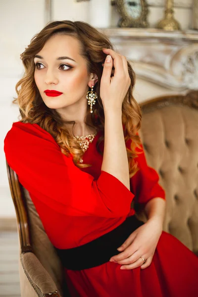La chica en un vestido rojo con joyas de traje de oro — Foto de Stock