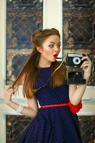 Девушка в платье в горошек с антикварной камерой — стоковое фото