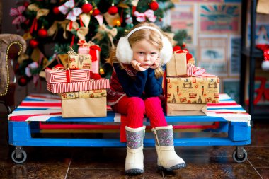 bir Noel köknar ağacı kırmızı tonlarda yakınındaki kız