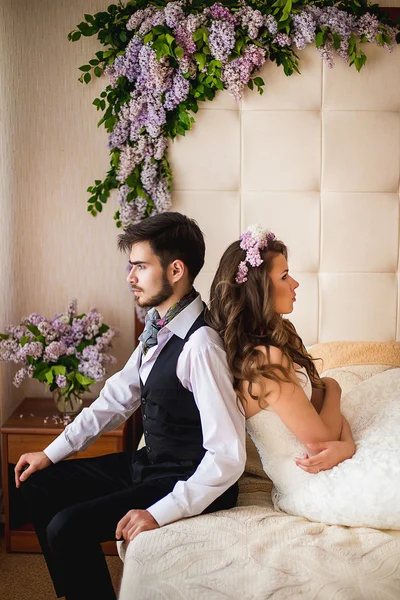 De bruidegom en de bruid op een bed — Stockfoto
