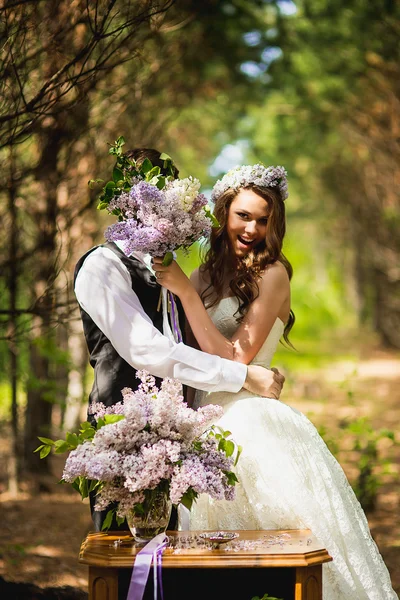 El novio con la novia en el bosque con una lila —  Fotos de Stock