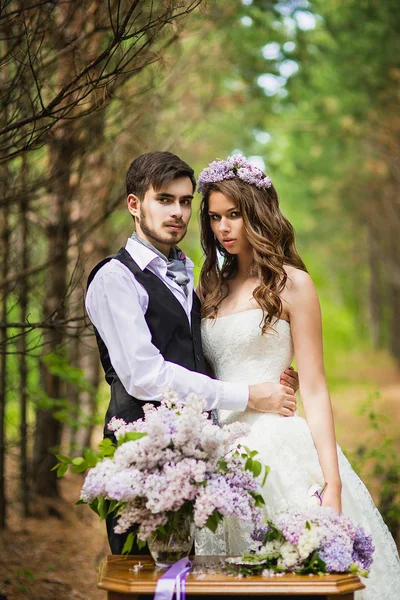 Наречений з нареченою в лісі з бузком — стокове фото