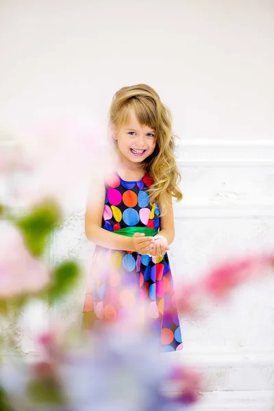 A menina posa perto de flores — Fotografia de Stock