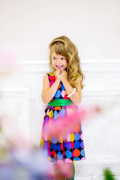 The little girl poses near flowers — Stock Photo, Image