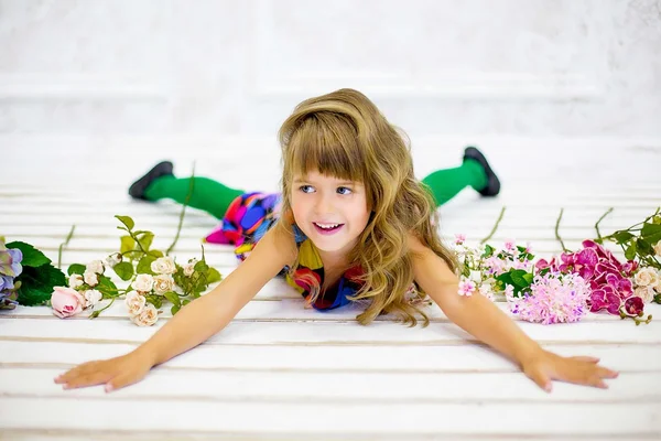 La niña posa cerca de las flores —  Fotos de Stock