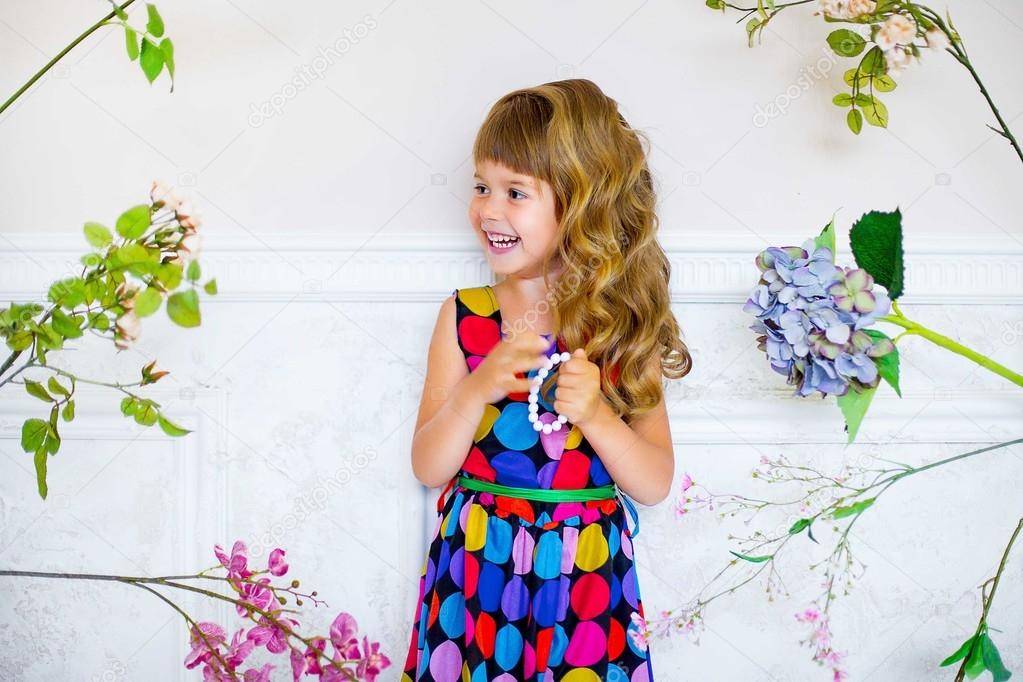 the little girl poses near flowers