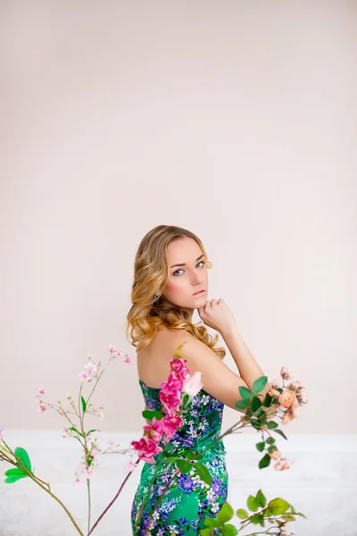 Das Mädchen posiert in der Nähe von Blumen — Stockfoto