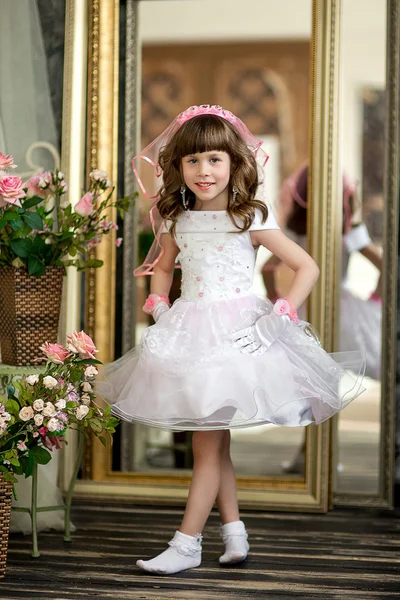 The little girl in an evening dress on a bed — Stock Photo, Image