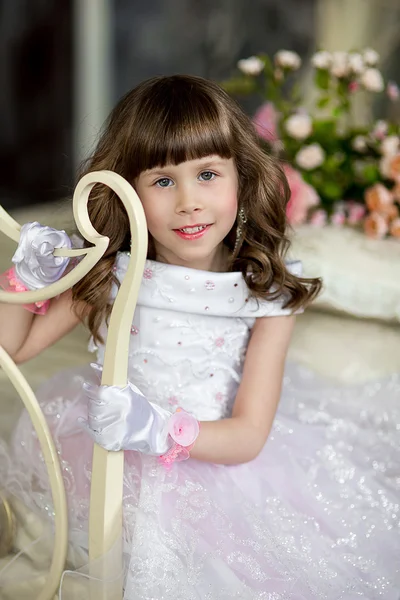 The little girl in an evening dress on a bed — Stock Photo, Image