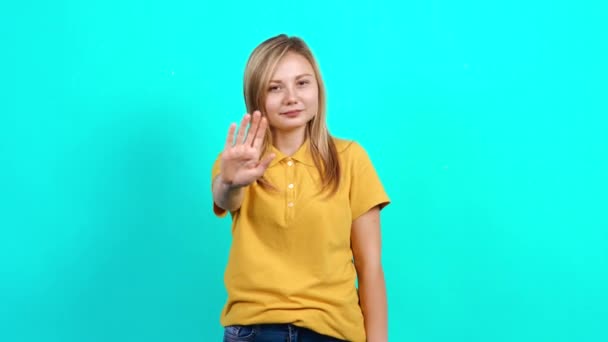Die bescheidene junge Frau legt ihre Handfläche vor sich hin und sagt Stopp. — Stockvideo