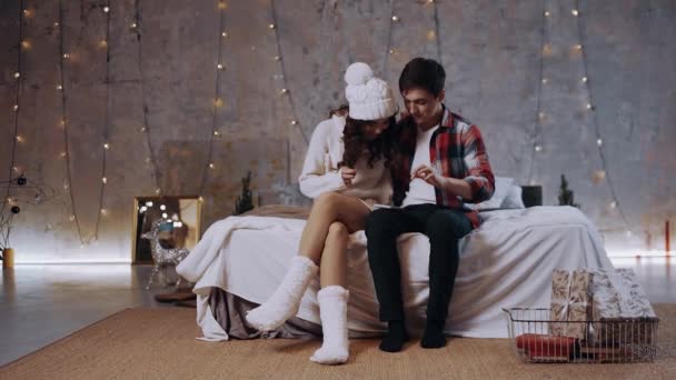 Jeune couple caucasien excité profitant des vacances d'hiver, regardant l'écran de téléphone mobile choqué — Video