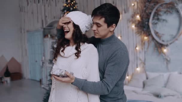 Ο νεαρός που έρχεται από πίσω βάζει το χέρι του στα μάτια των φιλενάδων του και της κάνει έκπληξη με ένα χριστουγεννιάτικο δώρο.. — Αρχείο Βίντεο