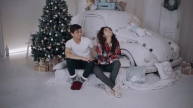 Erkek arkadaşının yanında oturan kızgın genç kadın erkek arkadaşına kurnaz hareketler yapıyor.