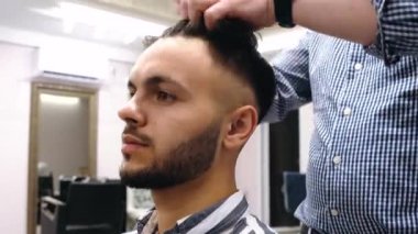 Enerji dolu yakışıklı genç bir adam kuaförde. Değirmenci işini dikkatli ve doğru yapar. Genç adam güzel sonuçtan memnun.