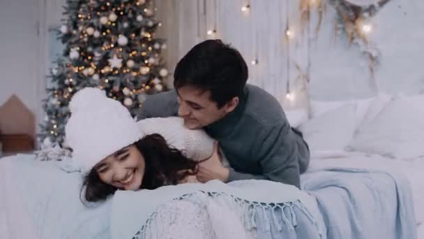 Dos jóvenes romántico y alegre chica y chico divertirse en la cama. — Vídeos de Stock