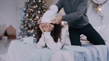 Evde dans eden genç bir çiftin portresi. Süslü bir Noel ağacının yanında.