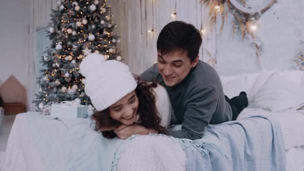 Портрет молодої пари, яка проводить час вдома у вітальні напередодні Різдва — стокове відео